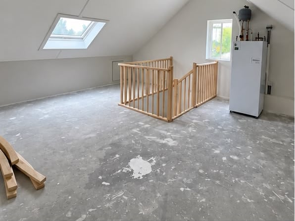 Pas afgewerkte zolder met houten trapleuning